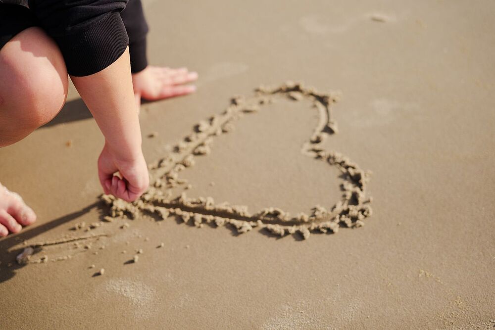 Bild zeigt Herz im Sand gemalt