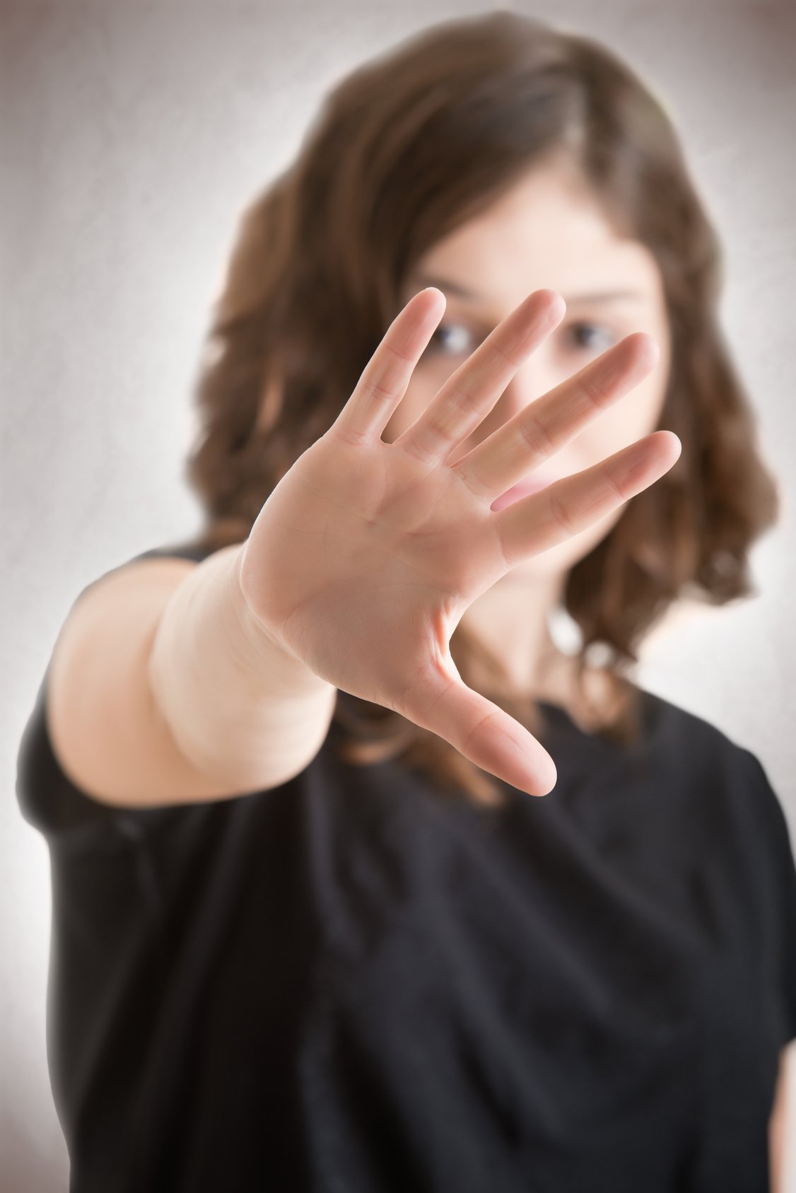 Frau hält ihre Handfläche mit ausgestrecktem Arm nach vorne