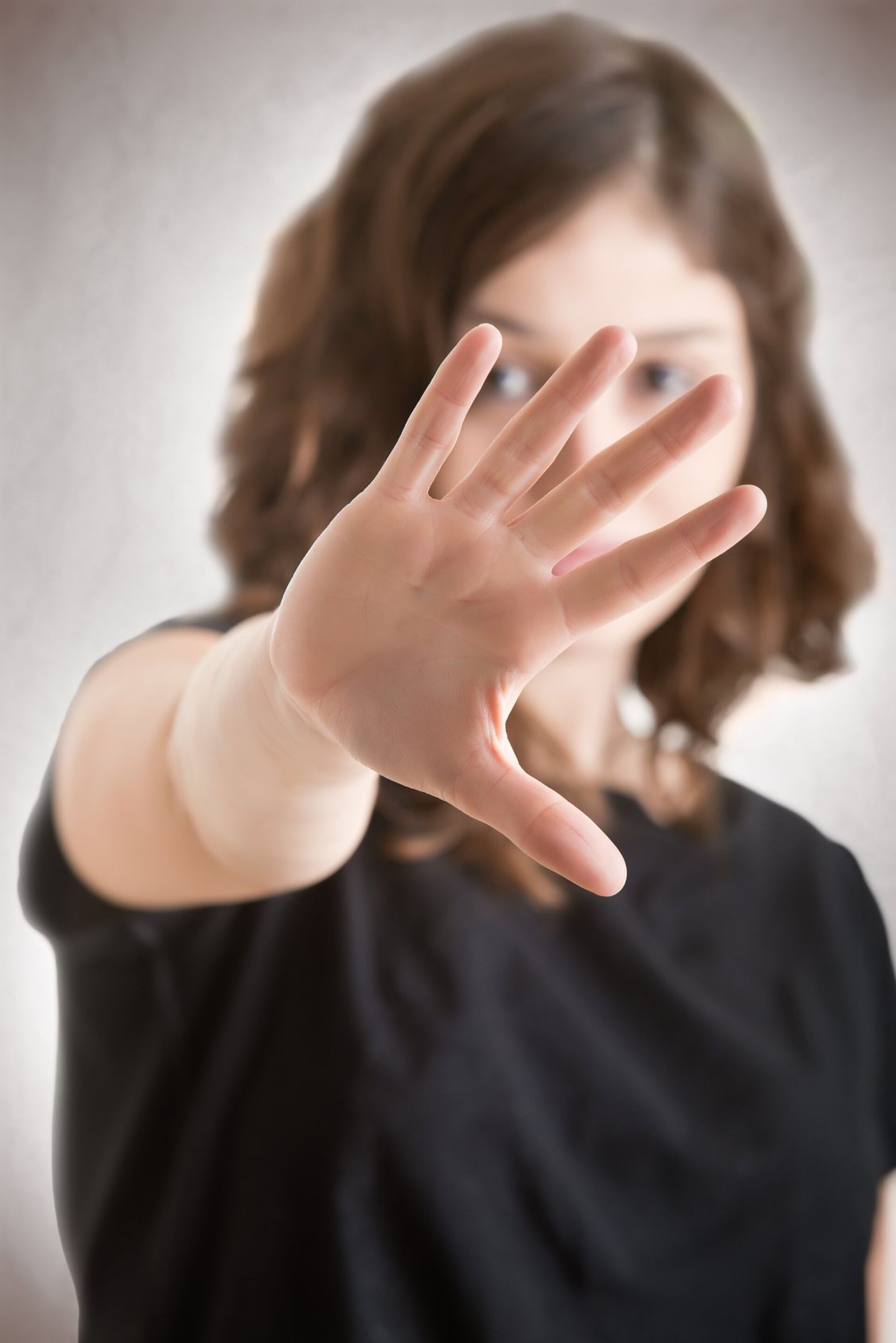 Frau hält ihre Handfläche mit ausgestrecktem Arm nach vorne