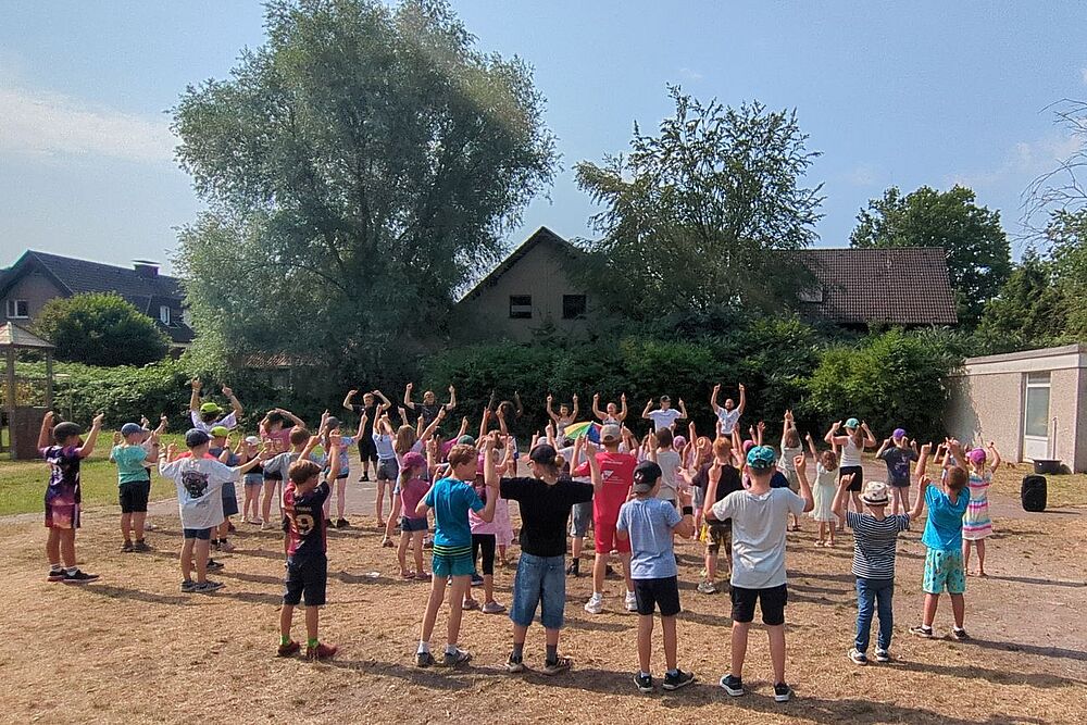 Bild zeigt eine große Gruppe Ferienkinder beim täglichen Tanz
